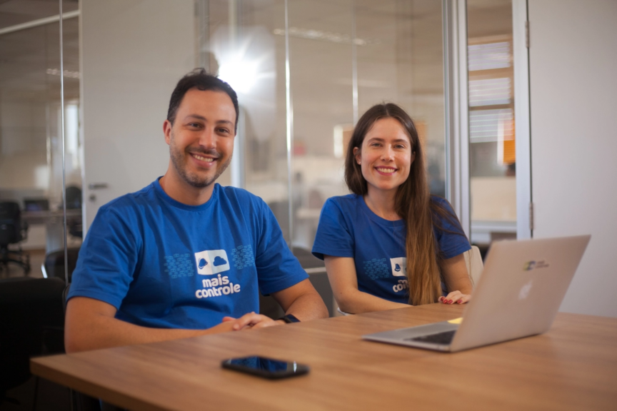 Setor de Rh da empresa sentados em frente ao computdor e sorrindo